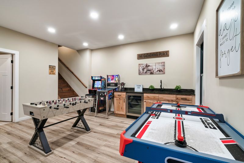Foosball and air hockey in front of the wet bar and arcade games