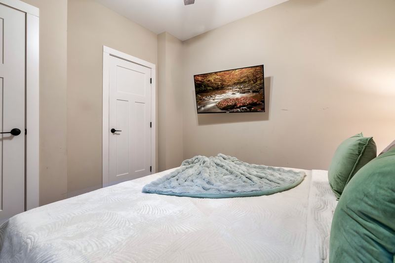 Second king bedroom with a wall-mounted TV across from the bed