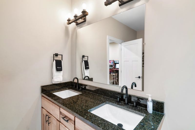 Lower-level bathroom with a double vanity and a large mirror