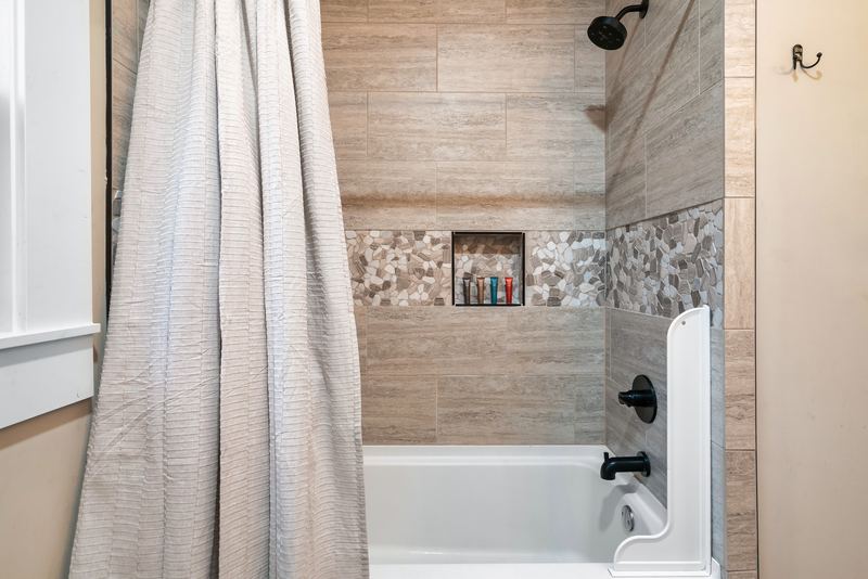 Tub and shower with a pebble-tile niche in the main-level bathroom