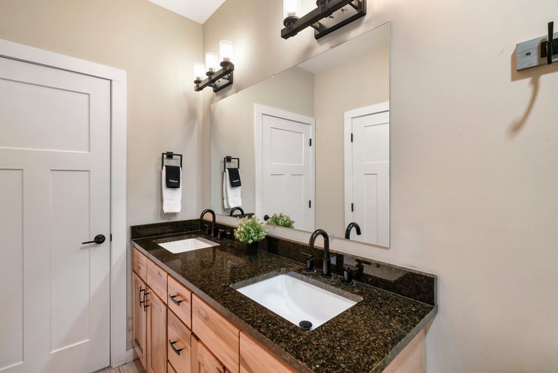 Main-level bathroom vanity with a granite top and black fixtures